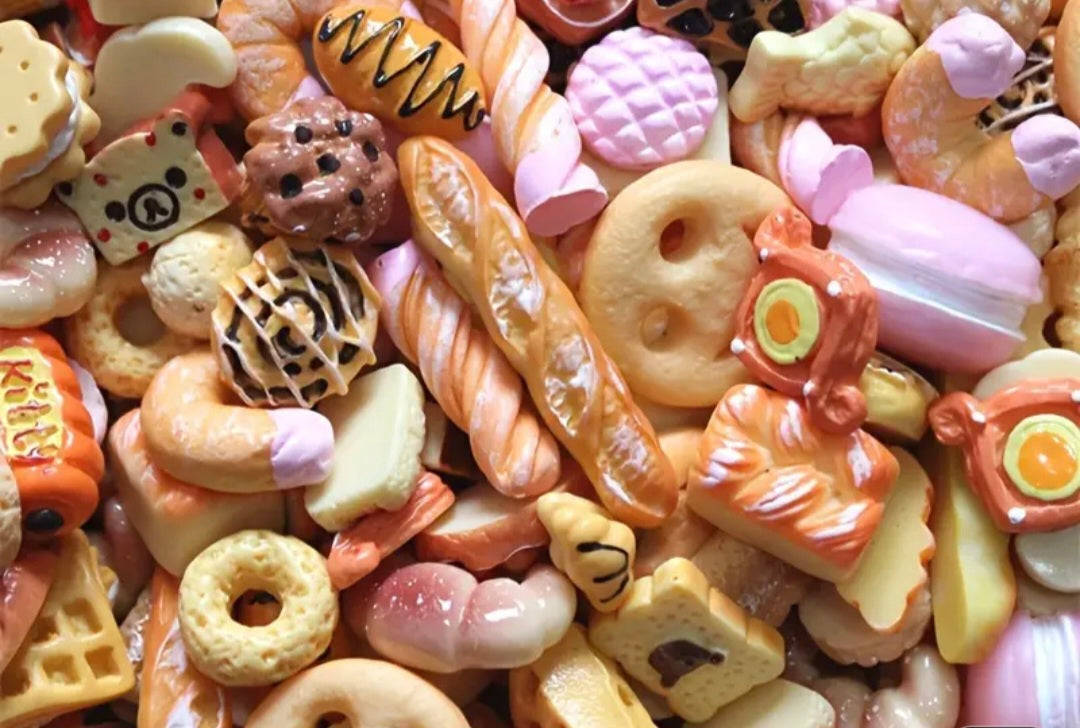 Assorted colorful miniature baked goods and pastries charms on a white background