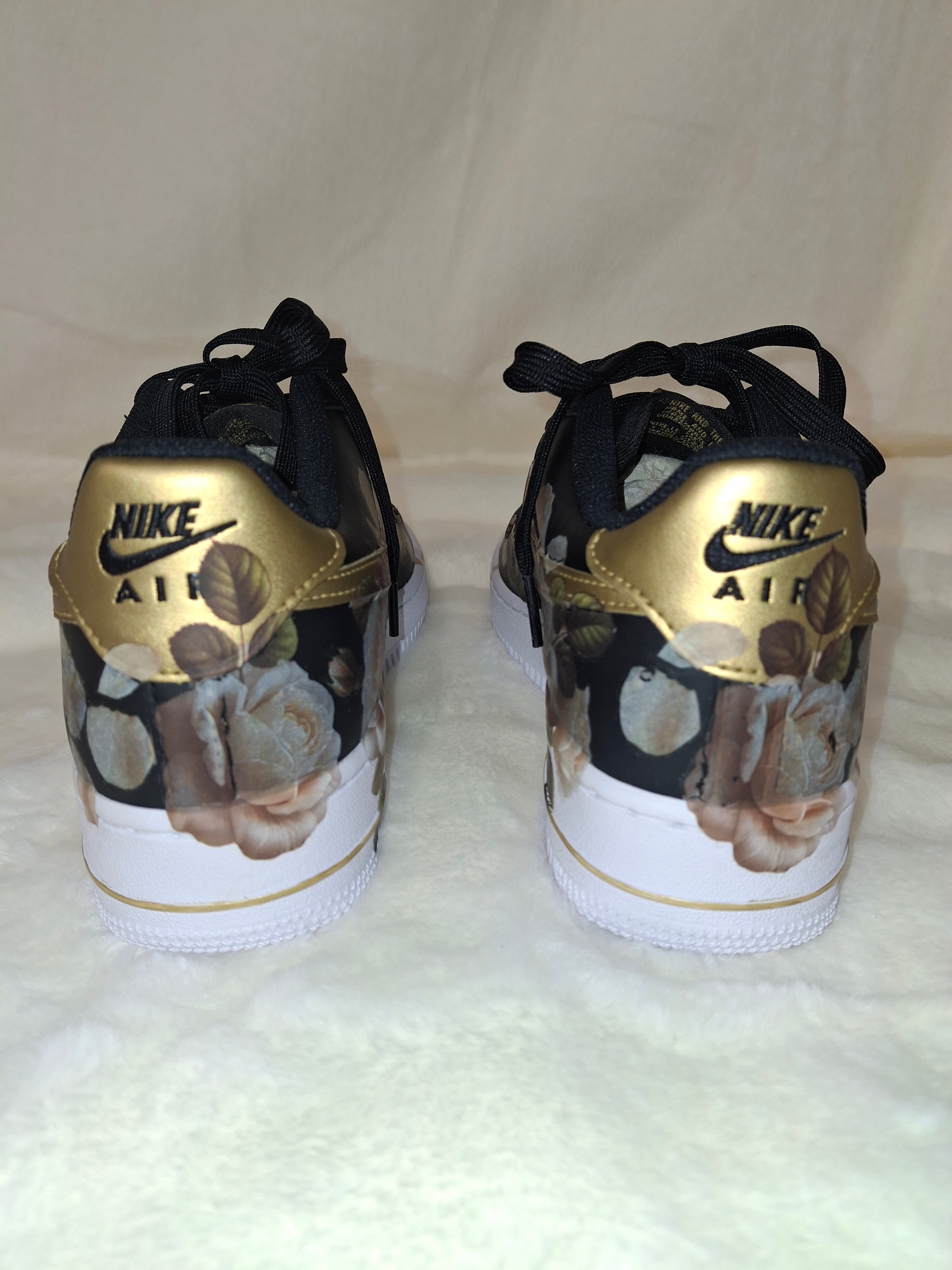 Pair of Nike sneakers with floral design and gold accents by Dressed and Done