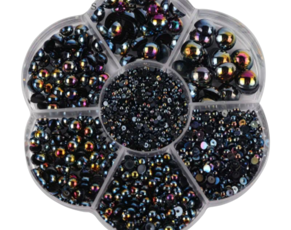 Black rhinestones of various sizes on a white background.