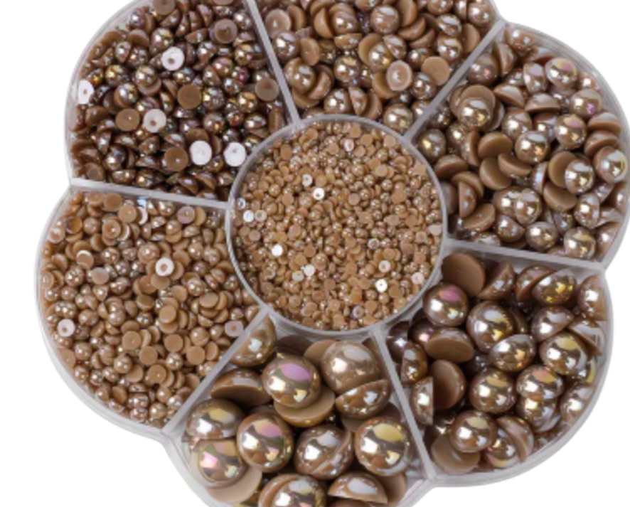 Round nail art pearls in various sizes and shades of brown on a white background.