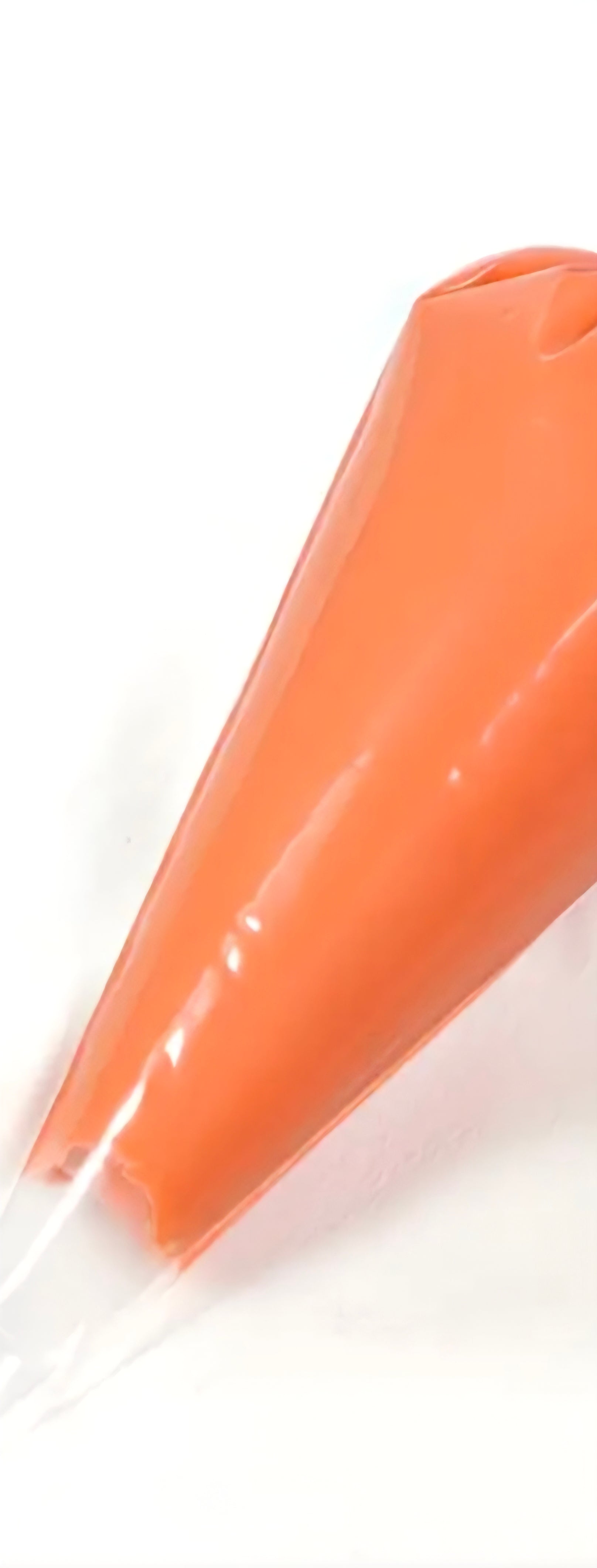 Carrot colored decoden cream glue tube on a white background.