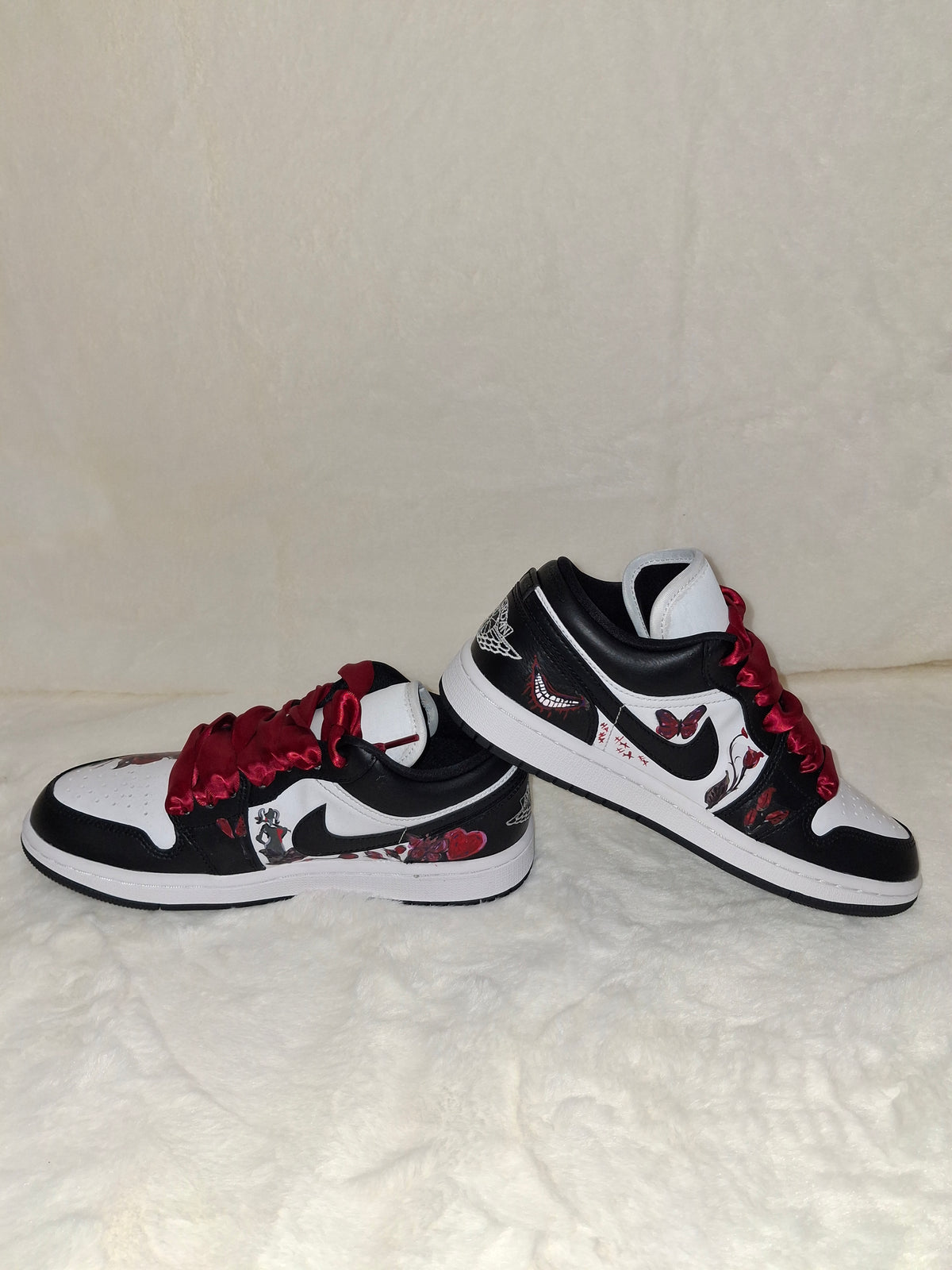 Custom black and white Jordan sneakers with hand painted designs and res ribbon laces, inside show view