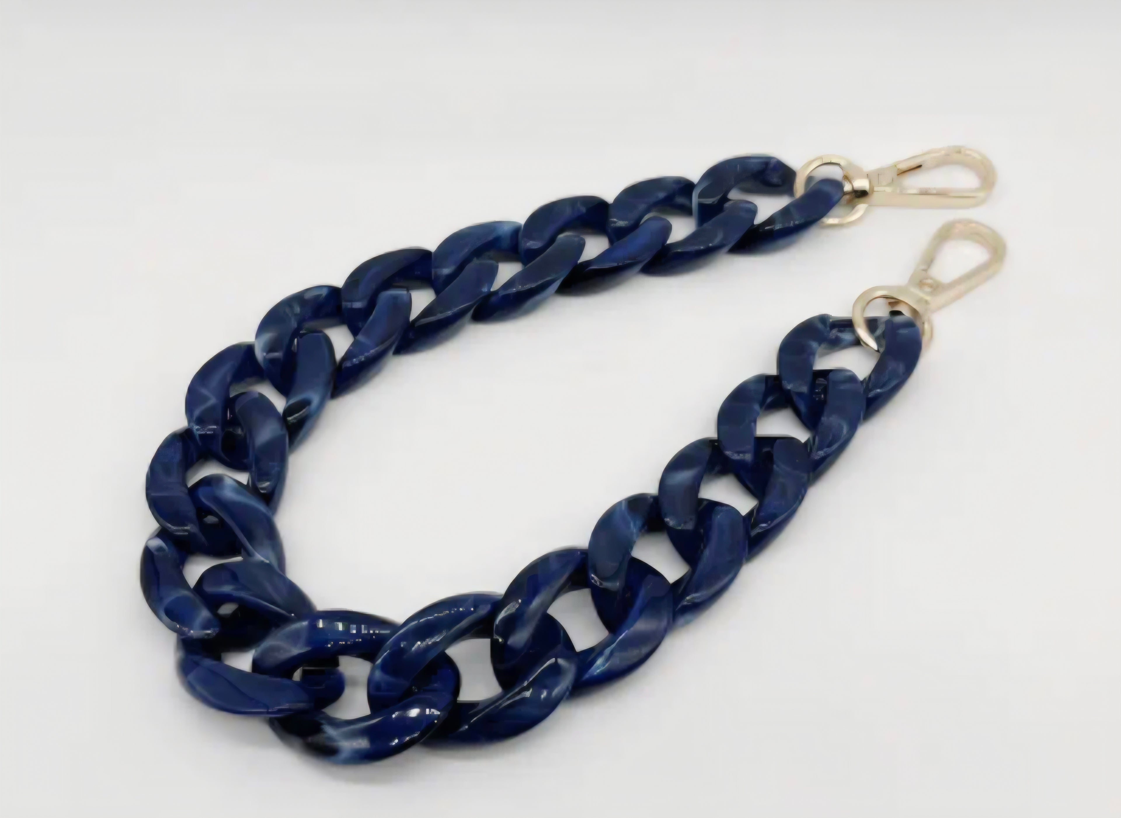 Navy blue chain strap with gold hardware on a white background