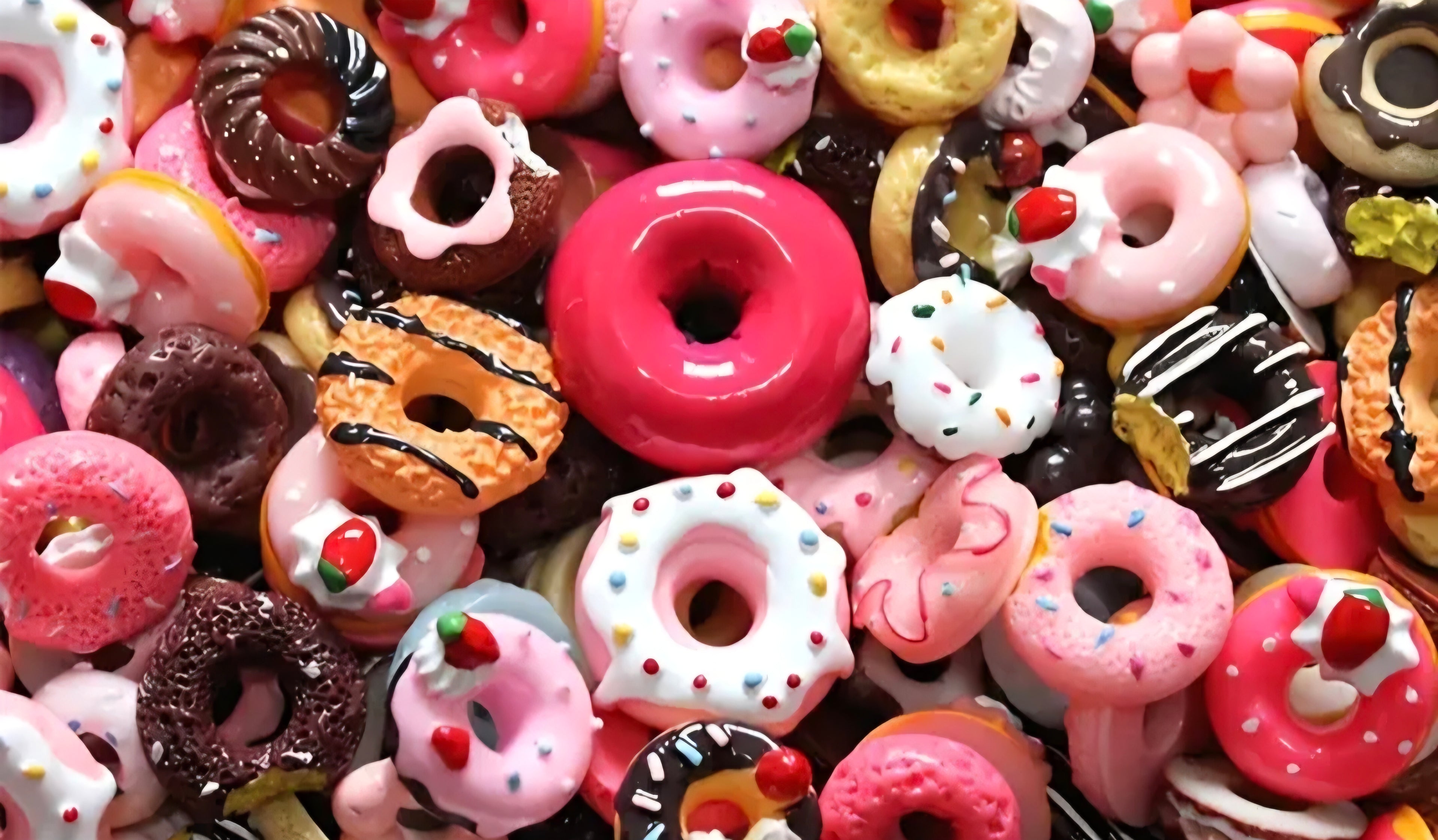 Assorted colorful donut-shaped charms with different toppings.