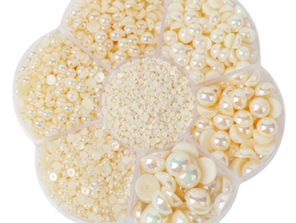 Set of pearl embellishments in a clear container on a white background