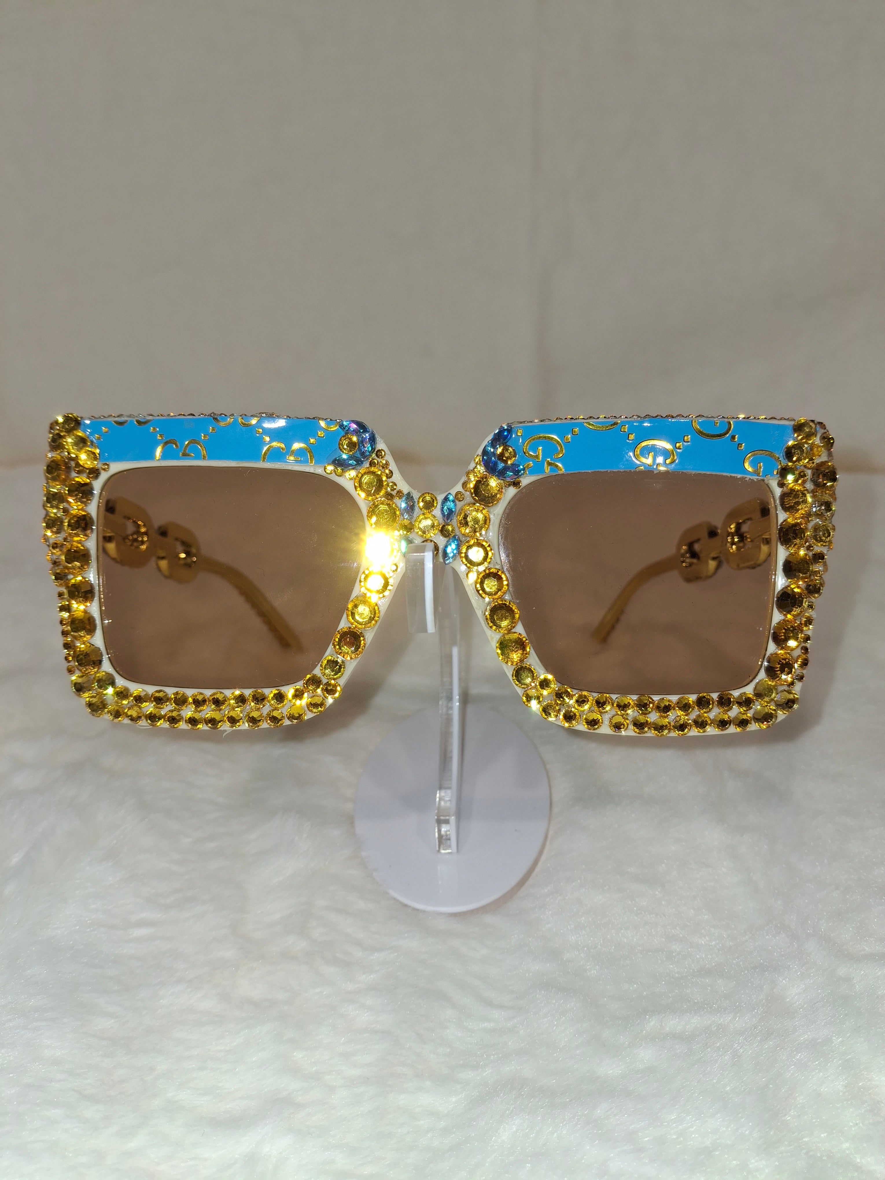 Decorative sunglasses with gold embellishments on a white background