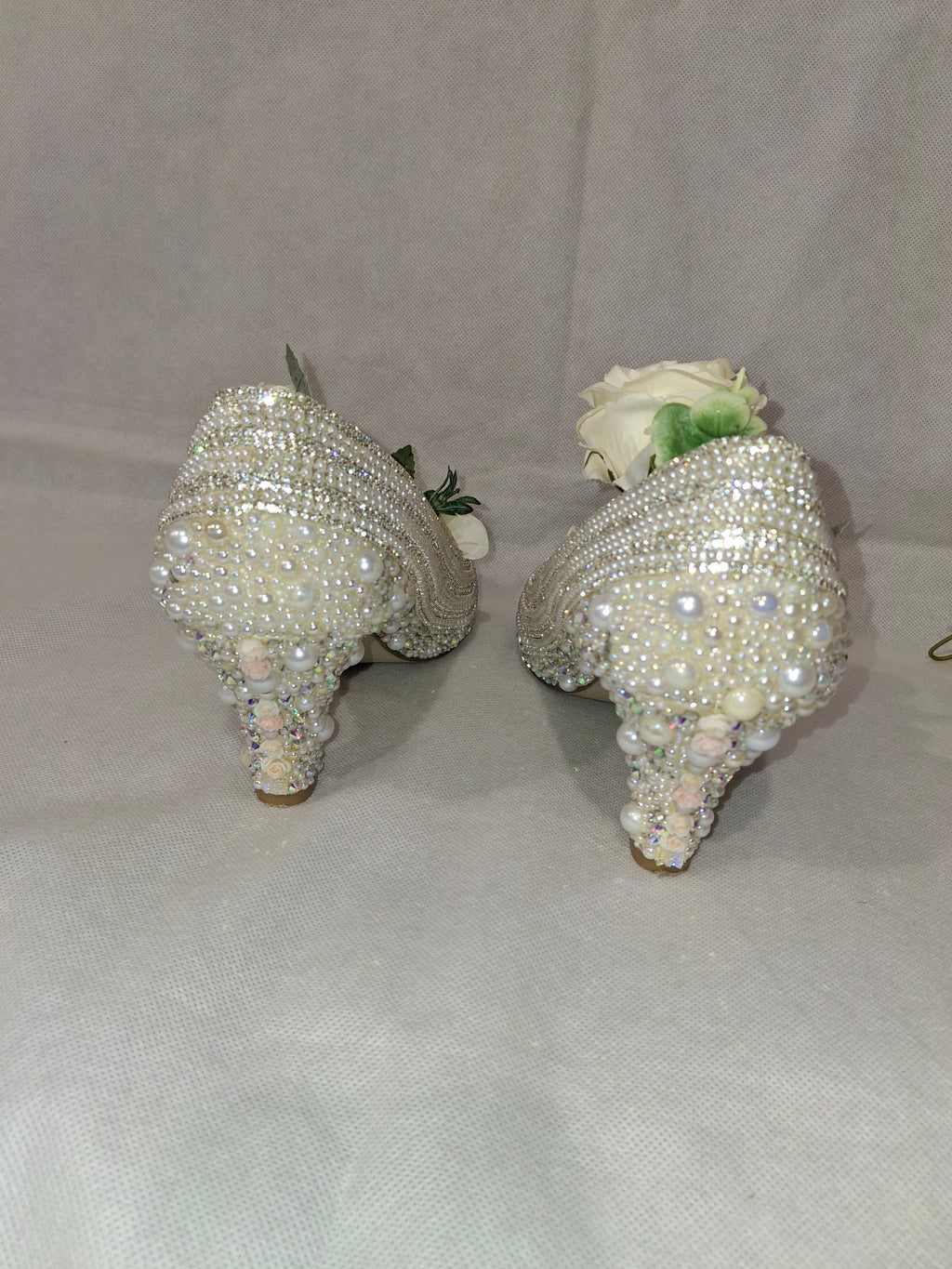 Two crystal-adorned heels on a white background