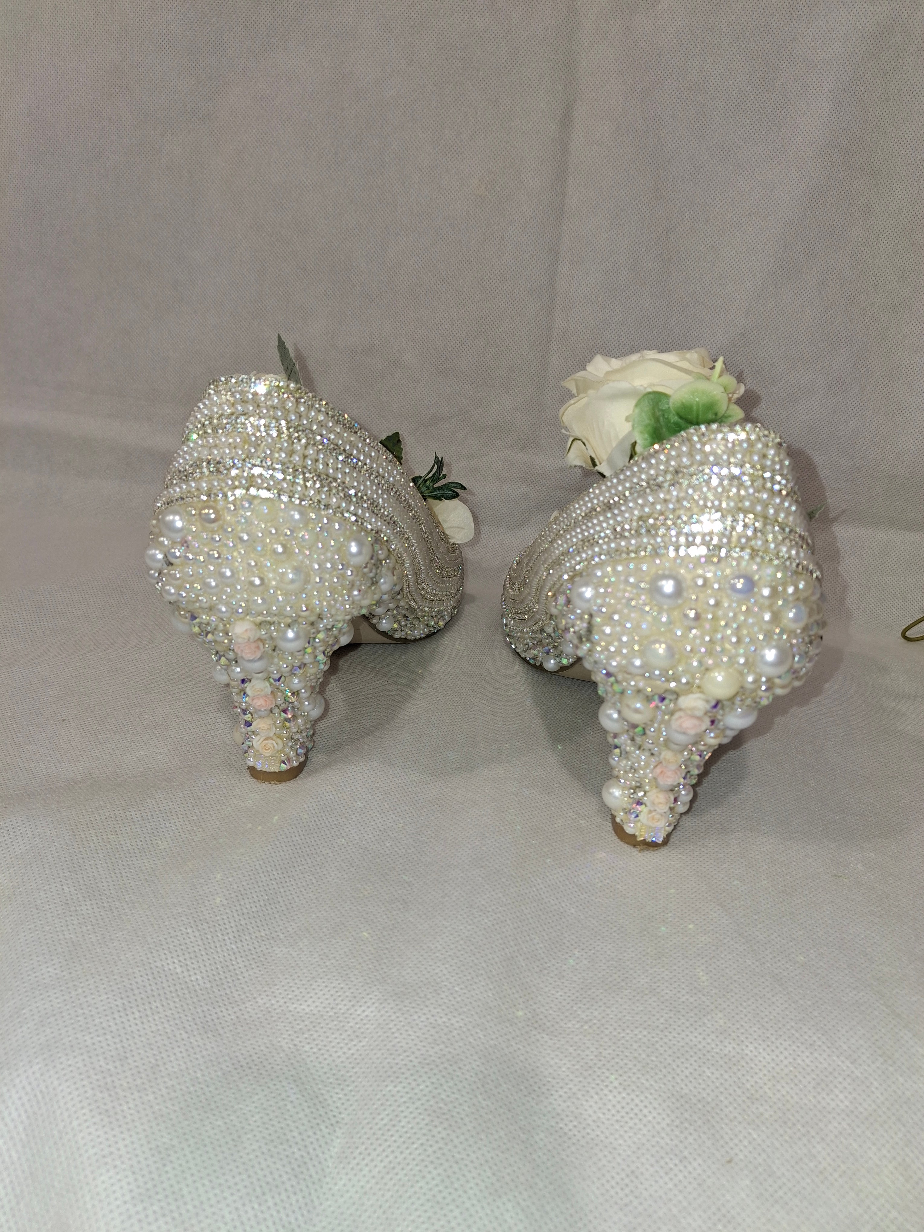 Two crystal-adorned heels on a white background