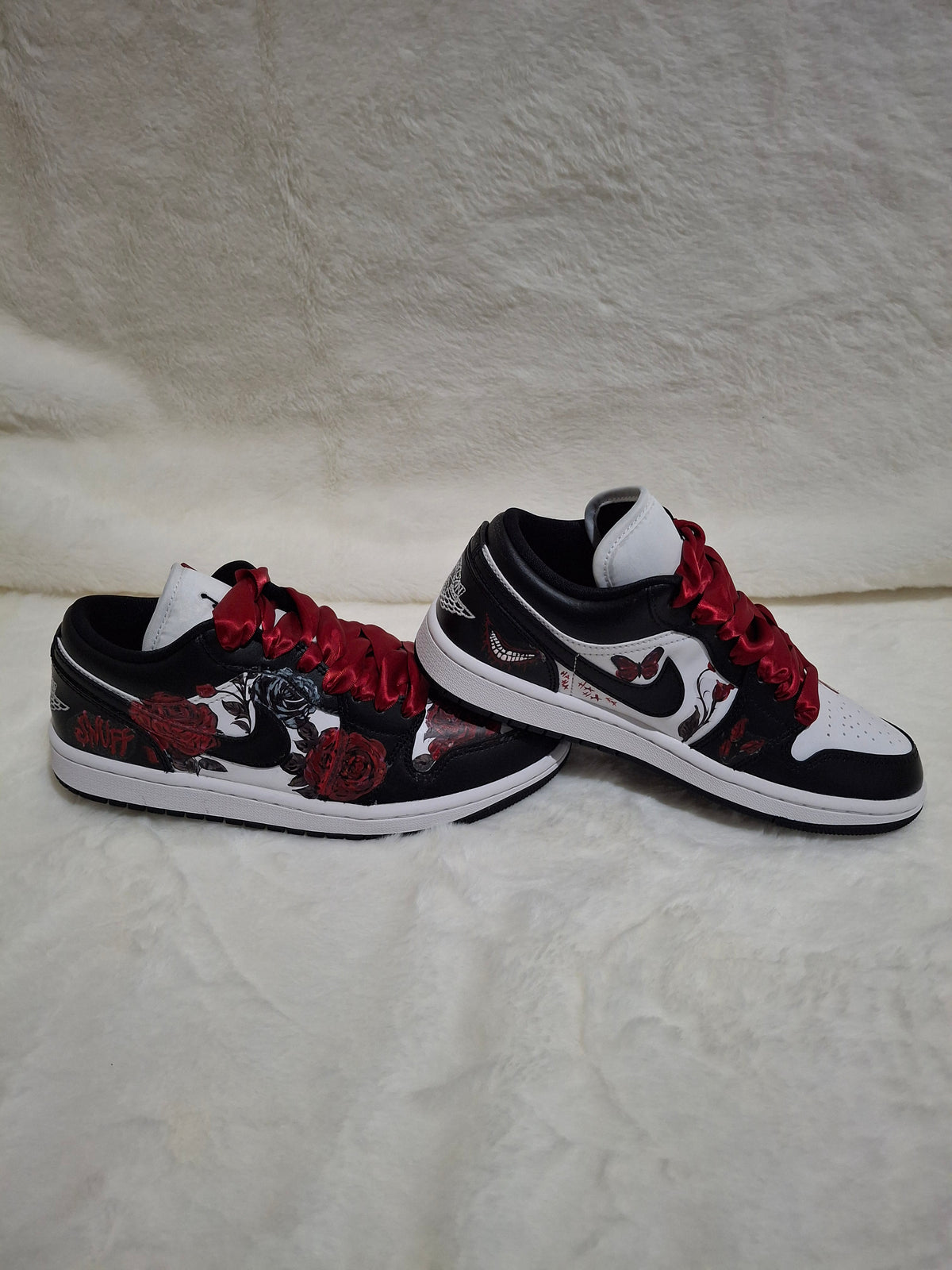 A pair of Nike Jordan sneakers with a black, white, and red colorway featuring a gothic rose 