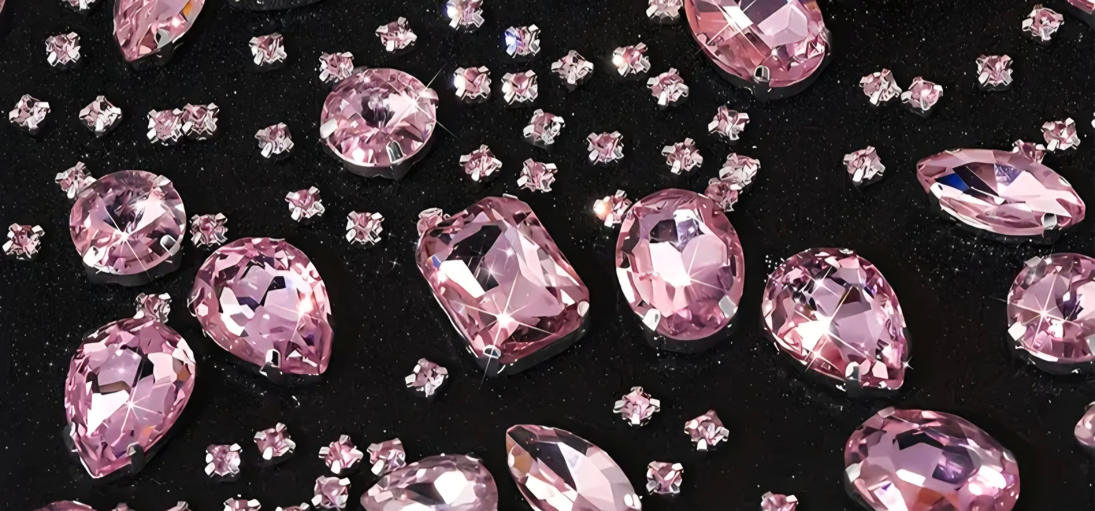 Light pink gemstones on a black background.