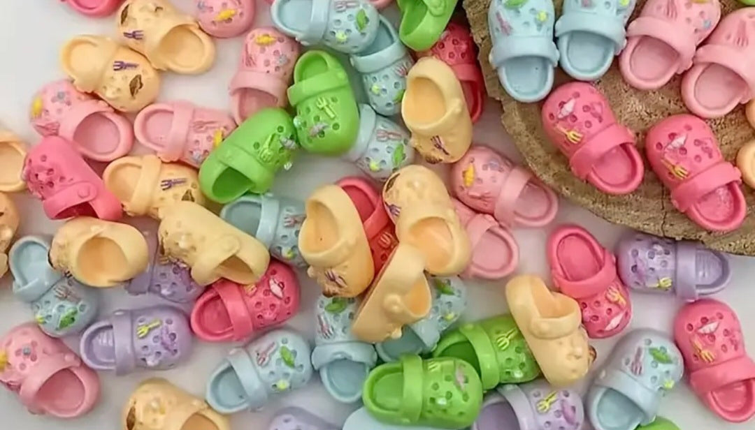 Colorful sandals charms with cartoon characters on a white surface