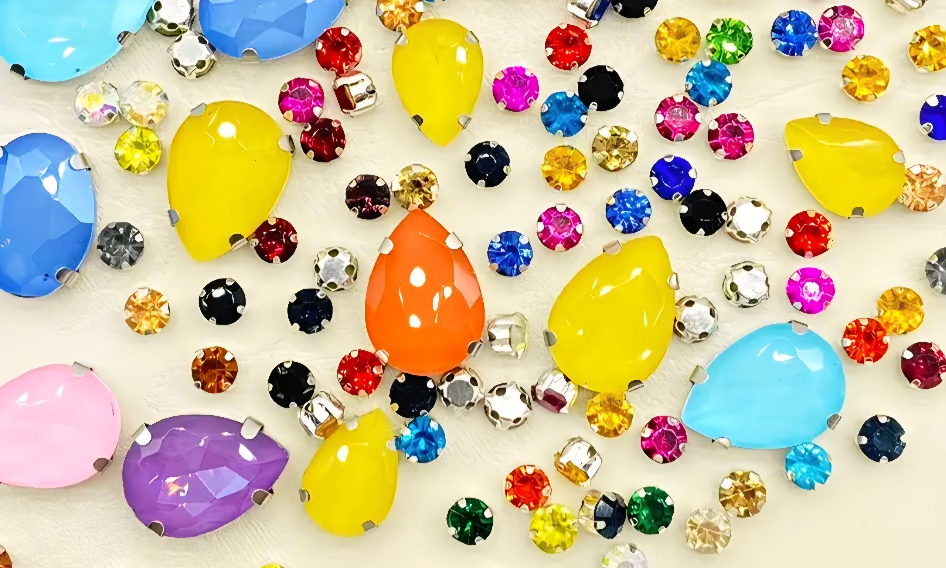 Assorted colorful rhinestones on a light background