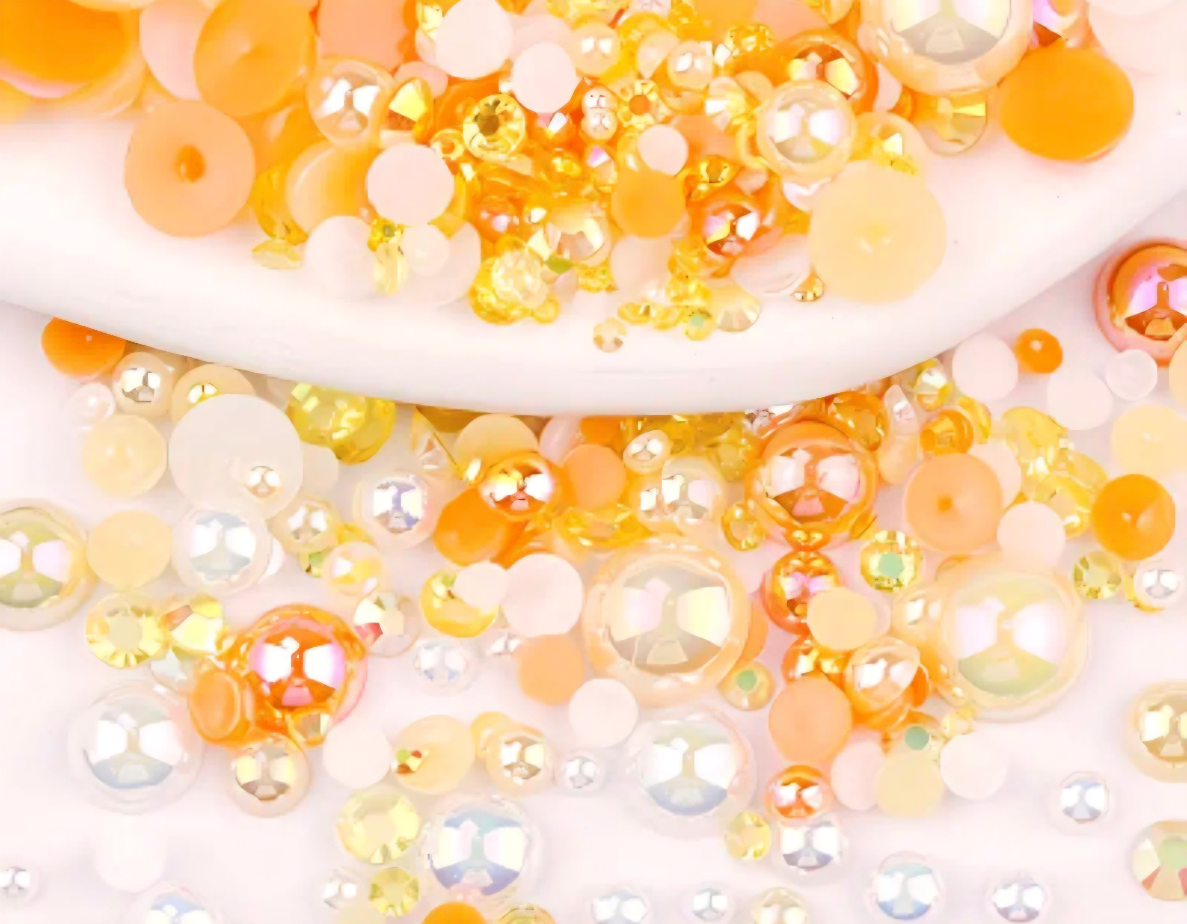 orange pearls and rhinestones on white background