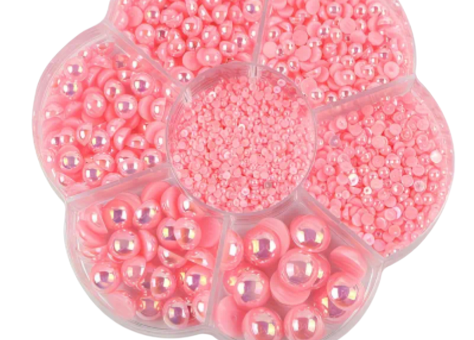Pink various size pearls in a clear plastic organizer on a white background