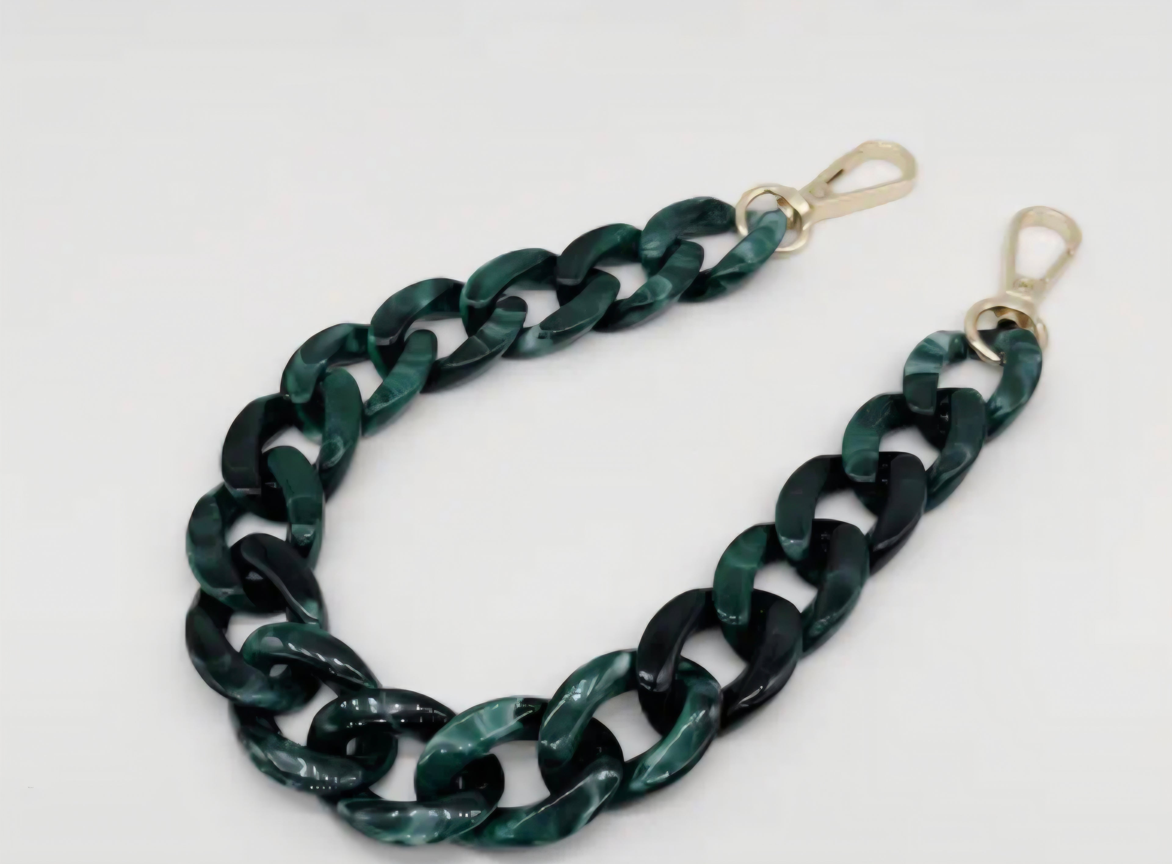 Green chain strap with gold clasp on a white background