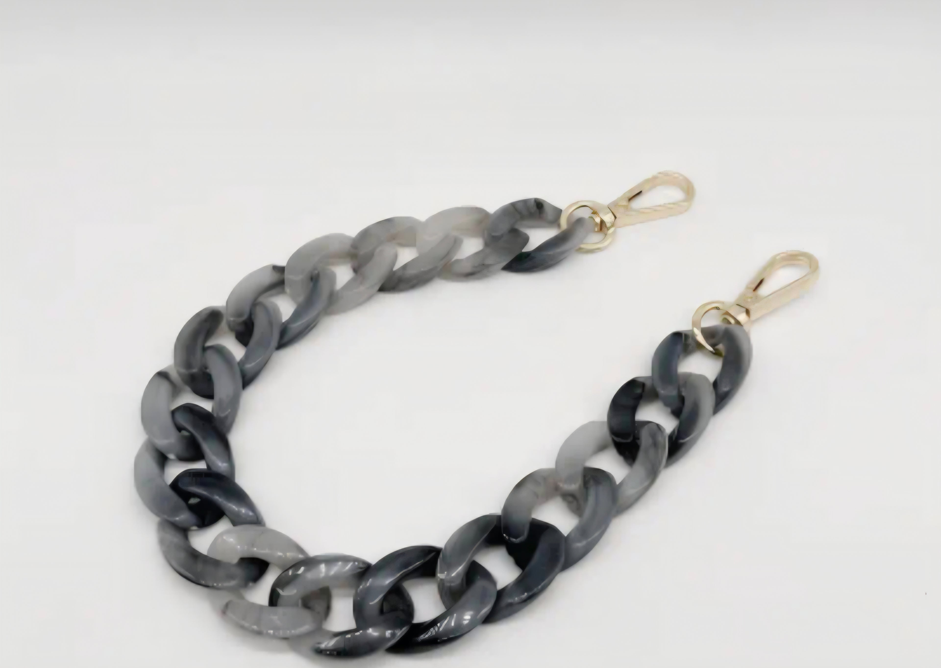 Gray chain strap with gold clasps on a white background.