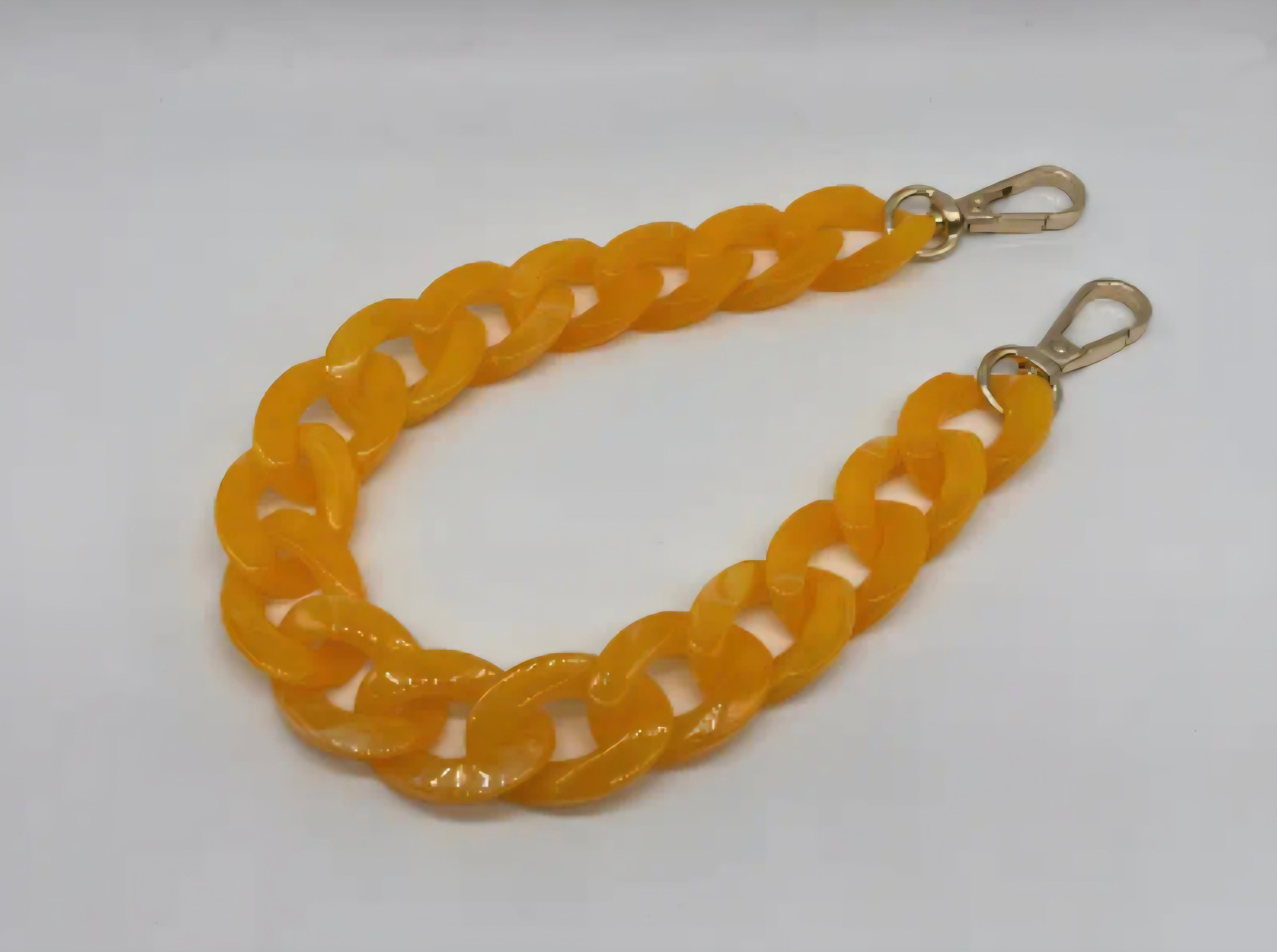 Yellow chain strap with gold hardware on a white background