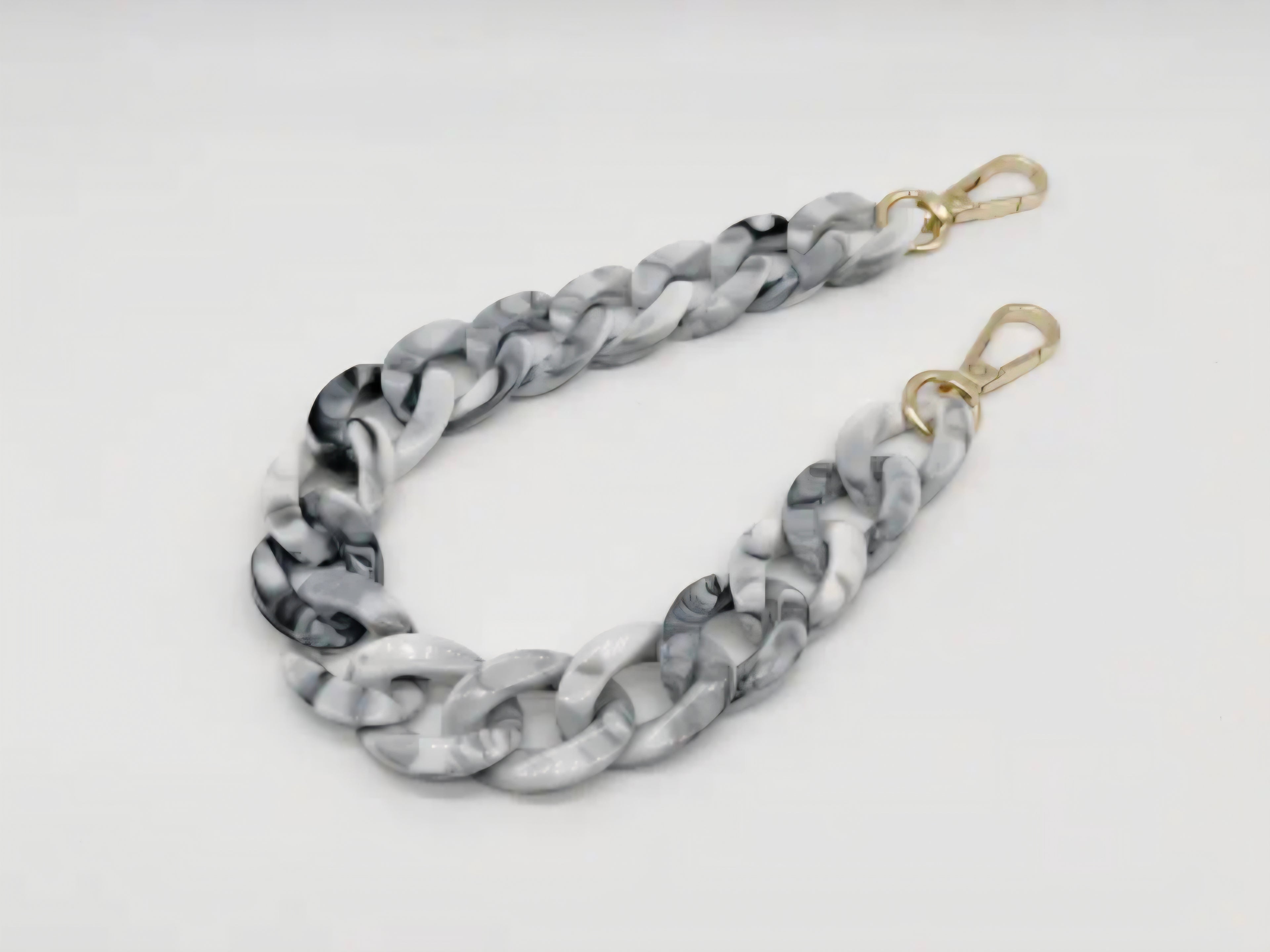 Marble-patterned handbag strap with gold hardware on a white background