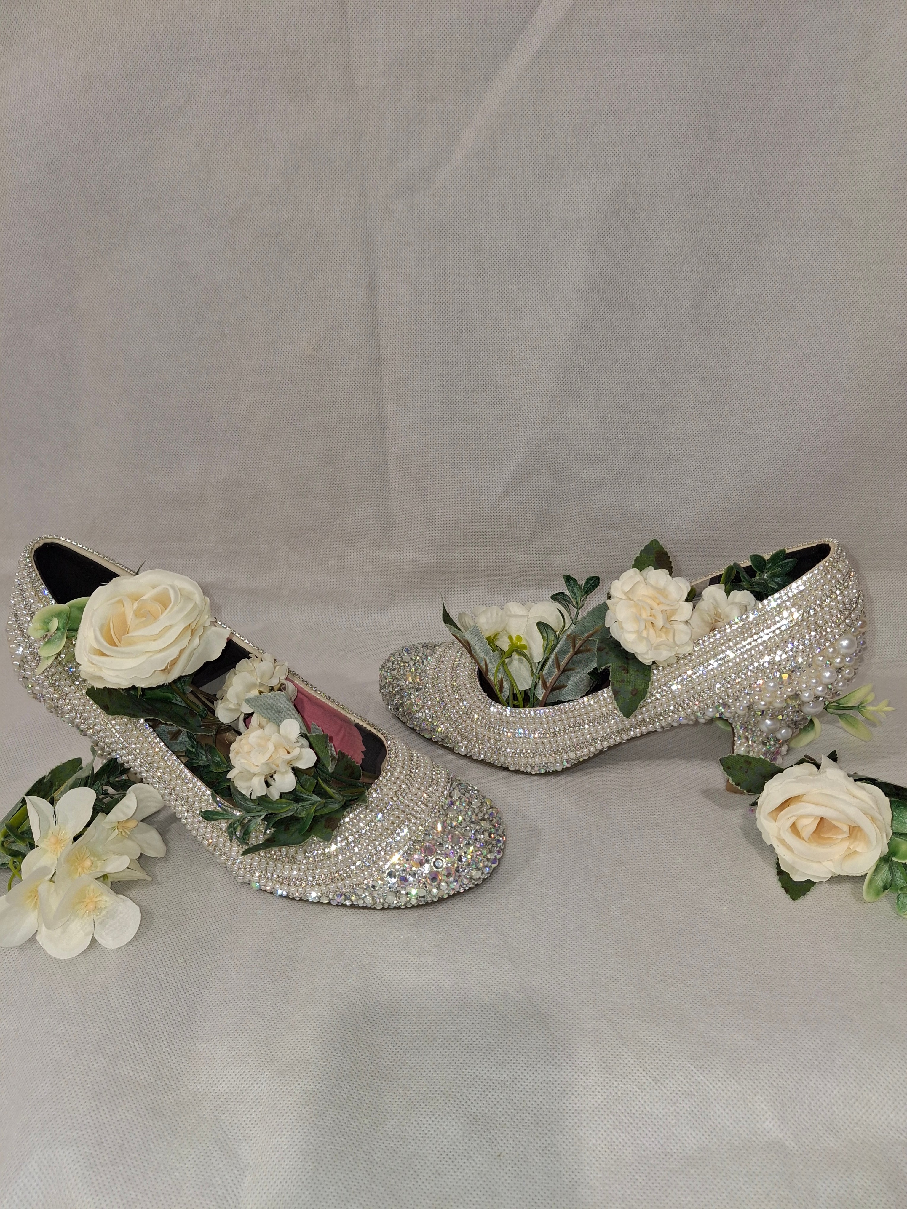 Decorative high-heeled shoes with flowers on a white background