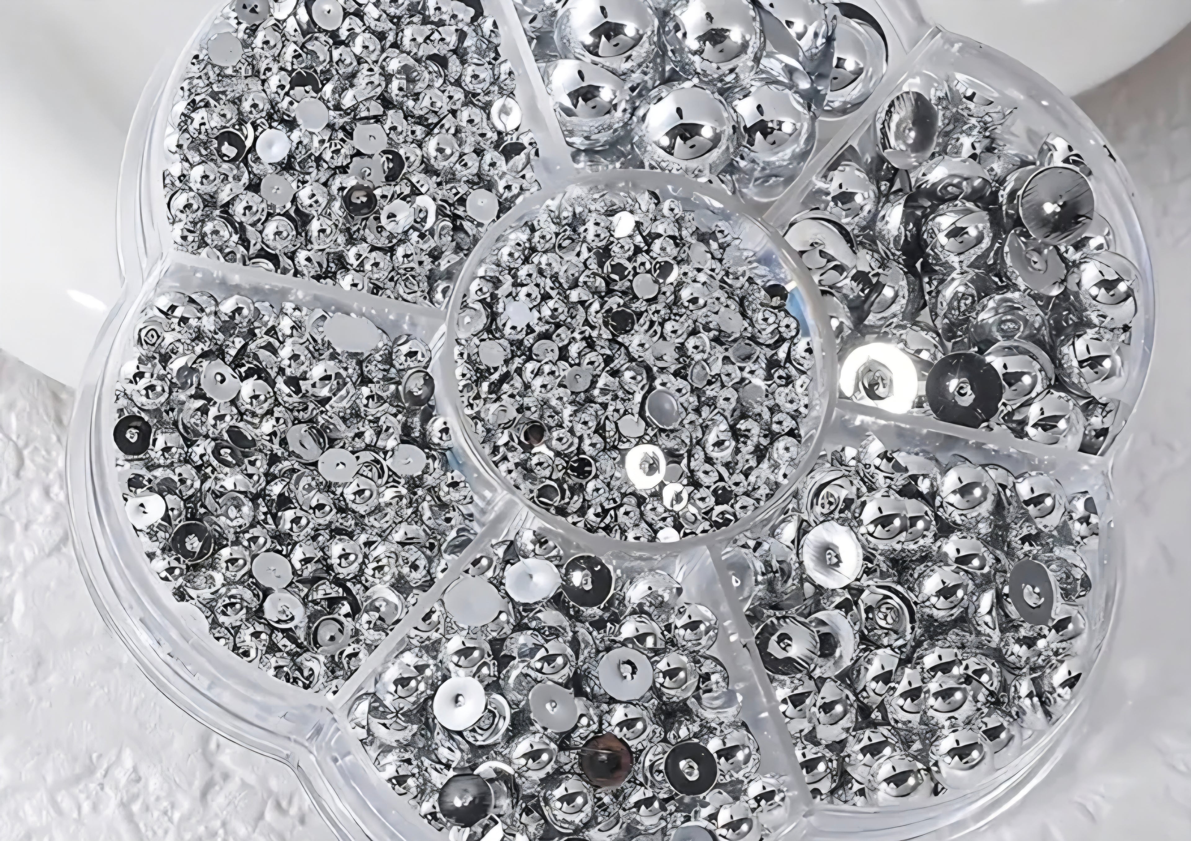 Close-up of a container filled with silver pearls for crafts