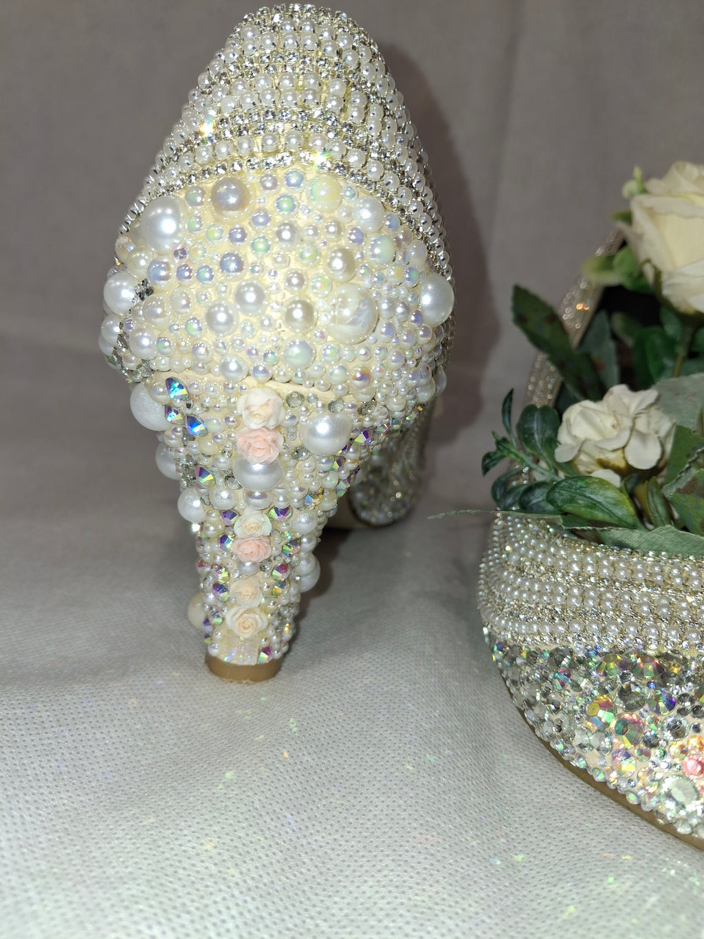 Embellished heel covered in pearls and crystals on a light background.