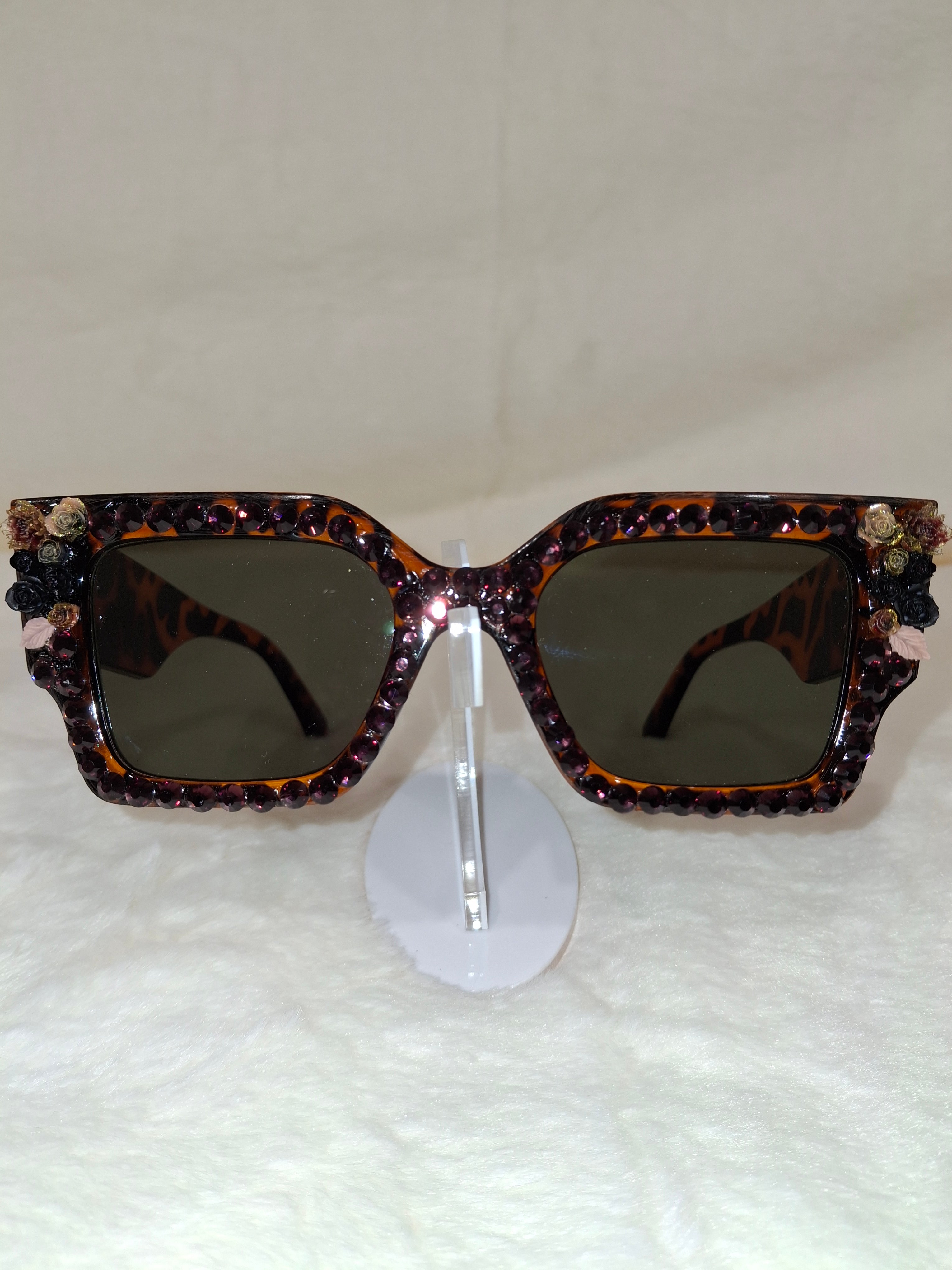 Sunglasses with decorative rhinestone frame on a white background